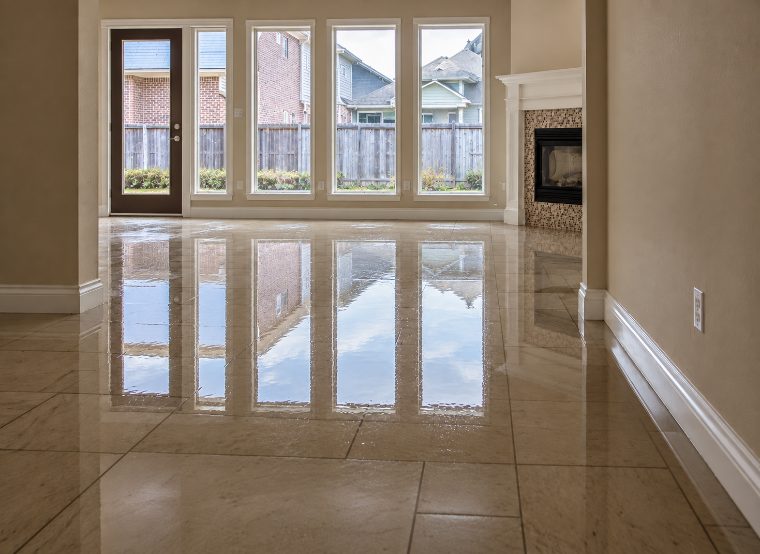 Standing water across the floor of an empty room